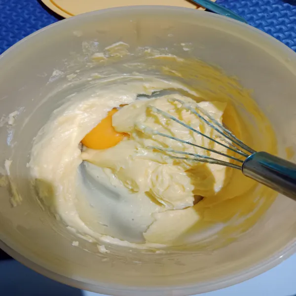 Tambahkan kuning telur, aduk hingga tercampur rata. 
Tidak perlu sampai mengembang ya.