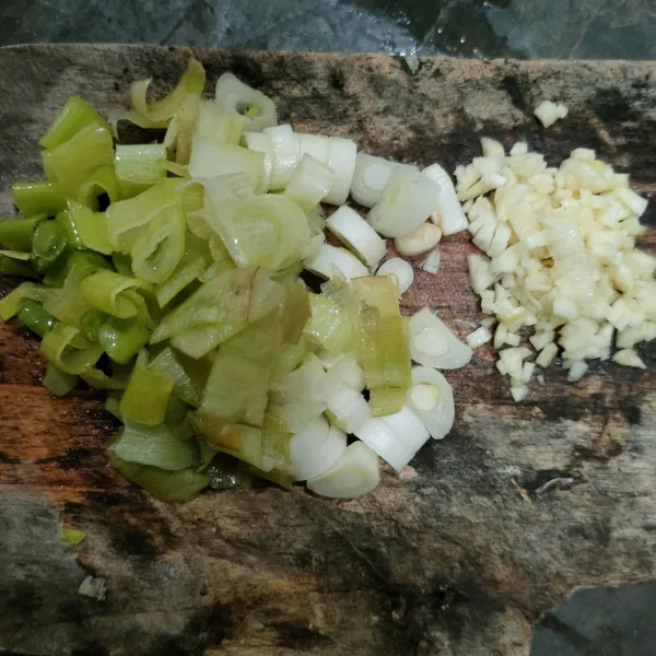Siapkan bawang putih dan daun bawang prei.