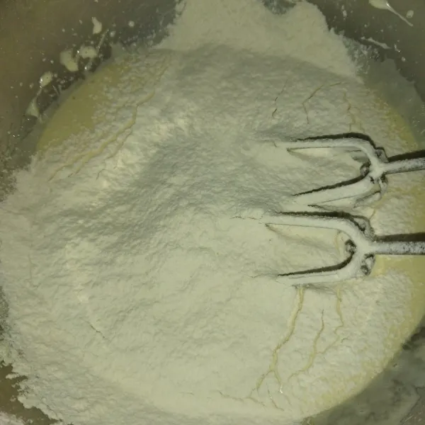 Lalu masukkan tepung terigu sambil diayak, mixer dengan kecepatan rendah, sebentar saja, asal tercampur rata.