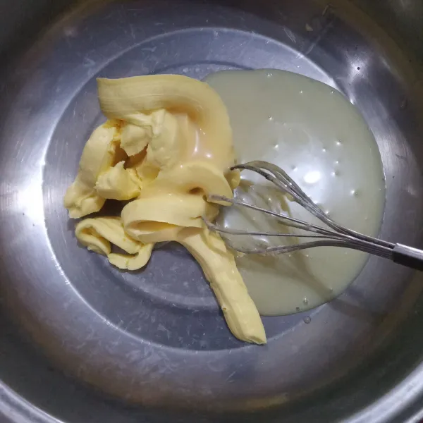 Kocok butter dan kental manis menggunakan whisk hingga tercampur rata.