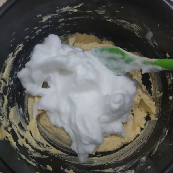 Masukkan kocokan putih telur ke dalam adonan tepung, aduk menggunakan spatula hingga tercampur rata.
