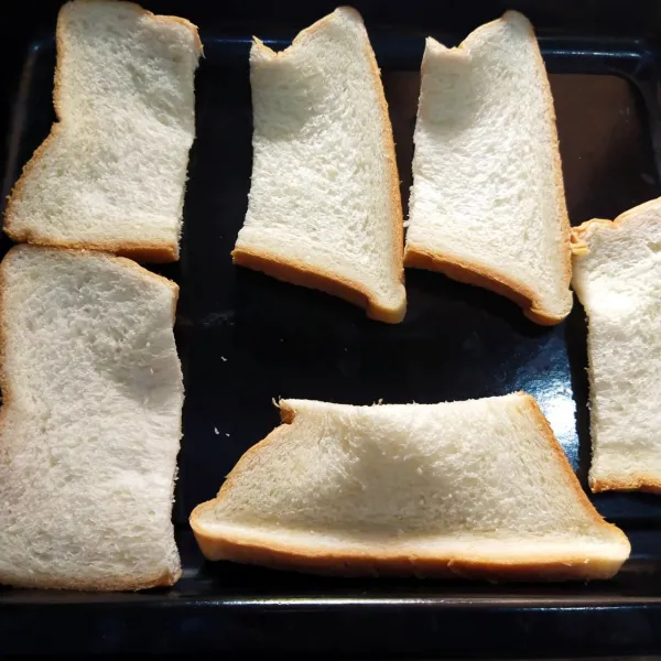 Belah roti tawar sesuai selera.