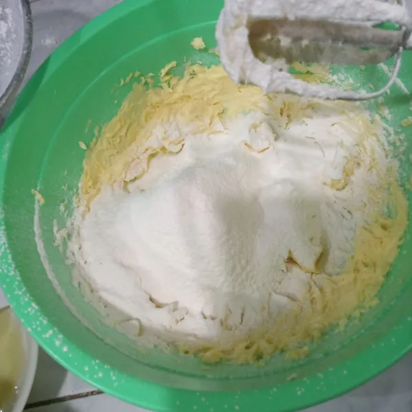 Masukkan tepung terigu sambil diayak.