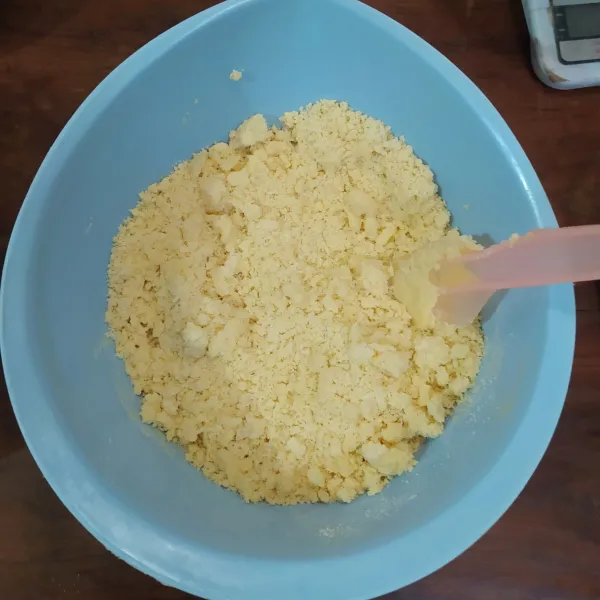 Masukkan campuran tepung sedikit demi sedikit, aduk dengan spatula.