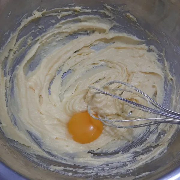 Kocok margarin butter dan gula sampai tercampur sebentar saja. Lalu masukkan kuning telur. Kocok kembali.