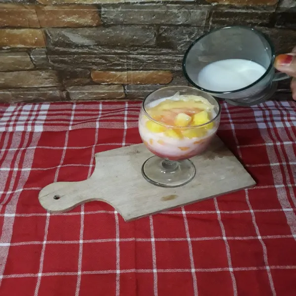 Lalu masukkan susu cair.
Aduk sebelum disajikan.
Es Blewah Semangka Susu siap untuk disajikan.