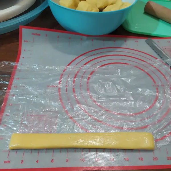 Cara mencetak kastengel tanpa cetakan ala saya, bagi adonan dan timbang dengan berat 50 gr. 
Bentuk memanjang menggunakan bantuan plastik cling wrap. 
Panjangnya 20 cm, lalu pipihkan dan rapikan.