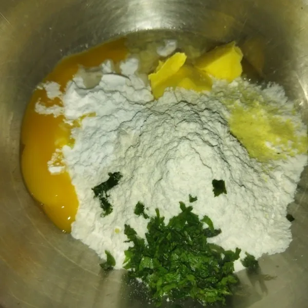 Siapkan wadah, masukkan tepung terigu, tepung sagu, margarin, kaldu bubuk, garam, telur dan potongan daun seledri.