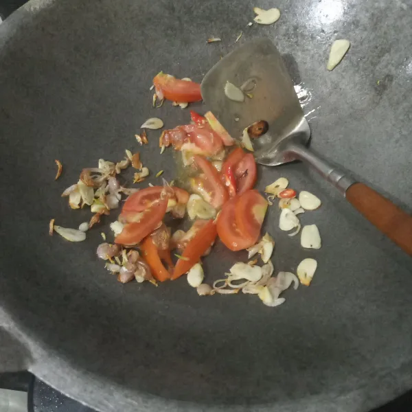 Masukkan irisan cabai dan tomat, aduk hingga layu.