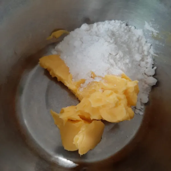 Kocok butter, margarin dan gula halus hingga tercampur rata. Masukkan kuning telur. Kocok kembali.