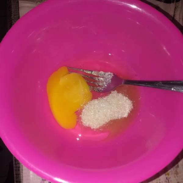 Dalam wadah, masukkan telur, gula pasir dan garam, aduk dengan garpu hingga gula larut.
