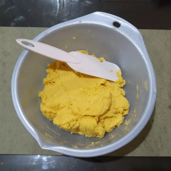 Tambahkan kuning telur, aduk dengan spatula hingga semua bahan tercampur rata.