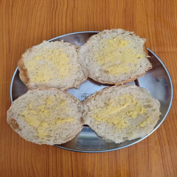 Belah 2 roti, oleskan margarine secukupnya di kedua sisi.