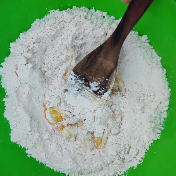 Masukkan tepung terigu, garam, kaldu bubuk dan telur ke dalam wadah. Kemudian uleni menggunakan spatula kayu hingga tercampur rata.