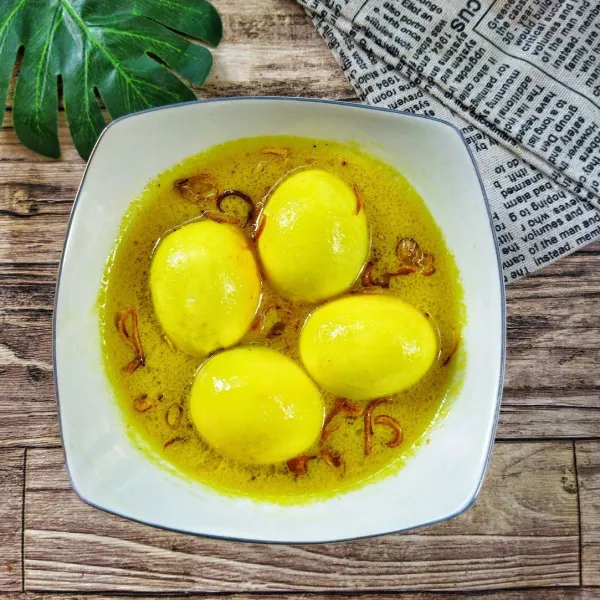 Sajikan opor kuning telur rebus dengan ditaburi bawang goreng.