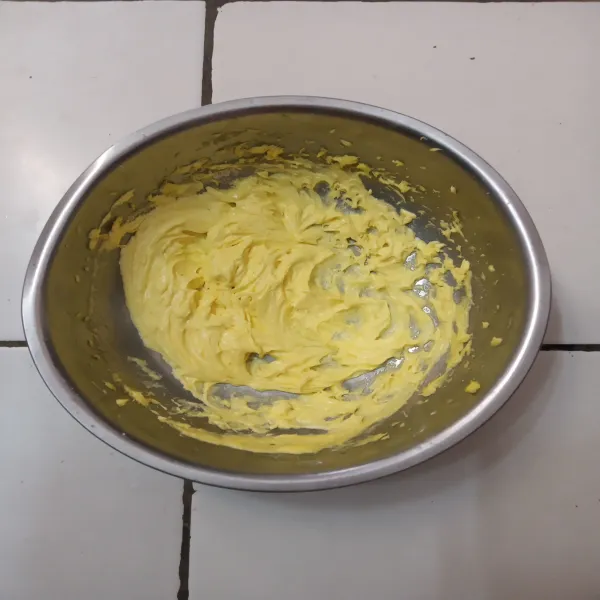 Mixer mentega, kuning telur dan gula halus hingga lembut.