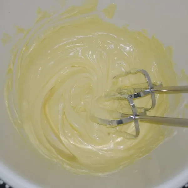 Kocok gula halus, mentega, dan margarin sampai putih pucat.