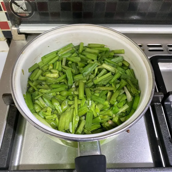 Didihkan air dan rebus selama 1 menit genjer yang sudah dipotong-potong untuk menghilangkan baunya. Lalu tiriskan.