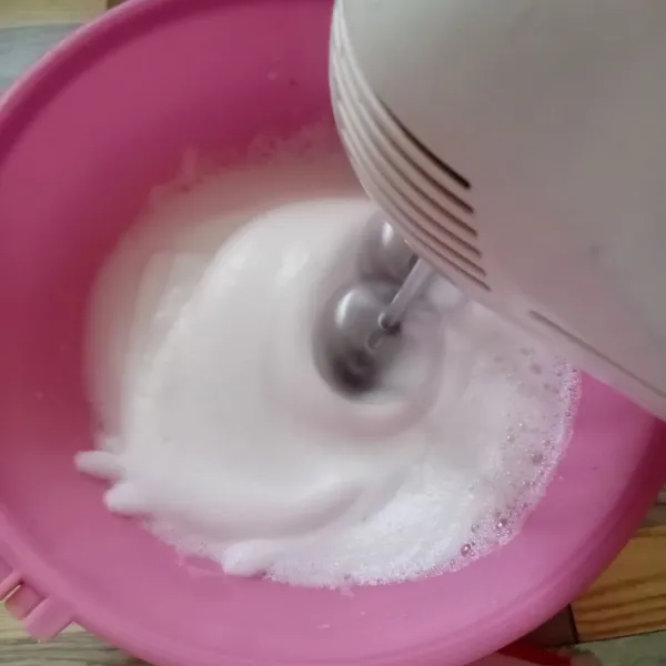 Mixer putih telur dengan kecepatan tinggi sampai kaku.
