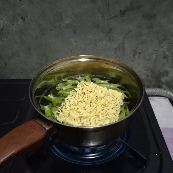 Tambahkan mie pipih dan rebus bersama mie sampai setengah empuk.