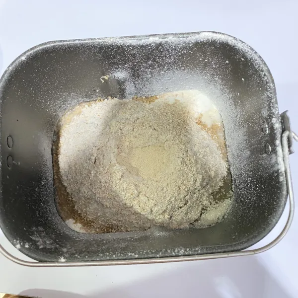 Masukkan semua bahan ke dalam loyang bread maker, diawali dengan air, tepung, pojok kanan atas garam, pojok kanan bawah gula pasir, lubangi di tengah untuk ragi instant.