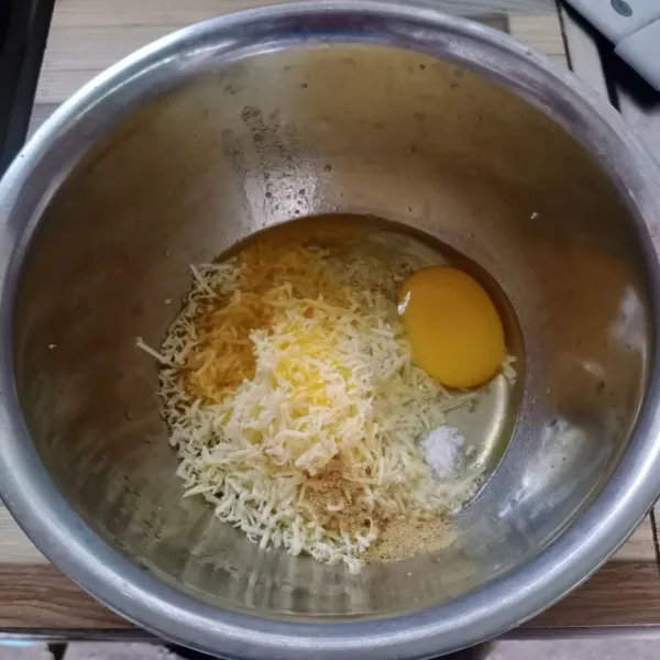 Masukkan telur, keju parut, margarin leleh, garam dan kaldu bubuk ked alam wadah.