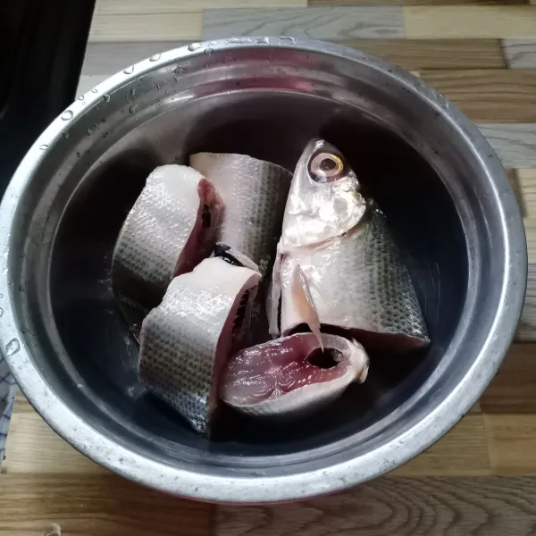 Cuci bersih ikan bandeng lalu balur dengan garam dan lada bubuk. Diamkan selama 5 menit.