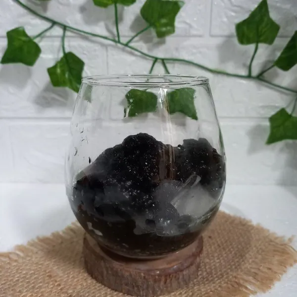 Masukkan cincau hitam serut ke dalam gelas.