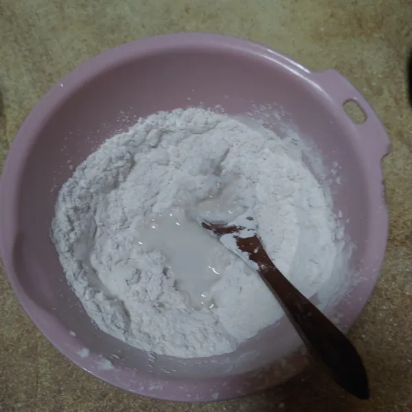 Campur tepung beras dan tepung tapioka, tambahkan air mendidih sedikit demi sedikit, aduk menggunakan sendok.
