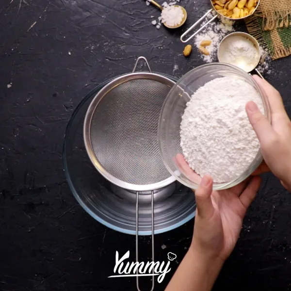 Di dalam sebuah mangkuk, ayak bersama tepung terigu, baking powder, baking soda dan garam lalu aduk hingga tercampur rata.
