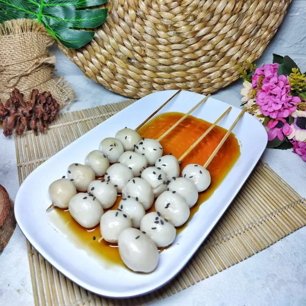 Sajikan Mitarashi Dango dengan saus di atas piring saji.
Taburi dengan sedikit wijen hitam.