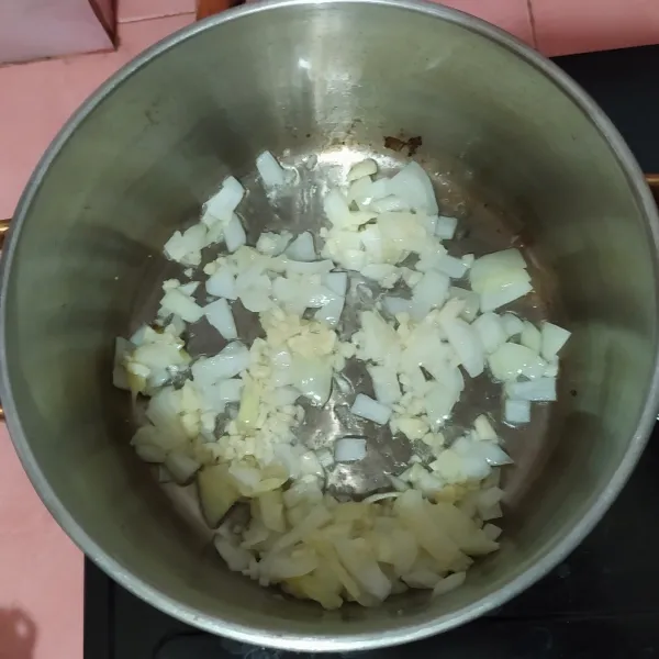 Tumis bawang bombay di panci, gunakan panci yang tebal supaya tidak mudah gosong. 
Lalu masukkan bawang putih.