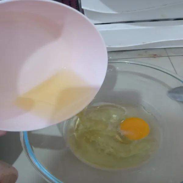 Whisk telur, minyak dan vanilla dalam wadah lain hingga tercampur rata.