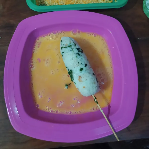 Buka plastiknya lalu celup ke kocokan putih telur.