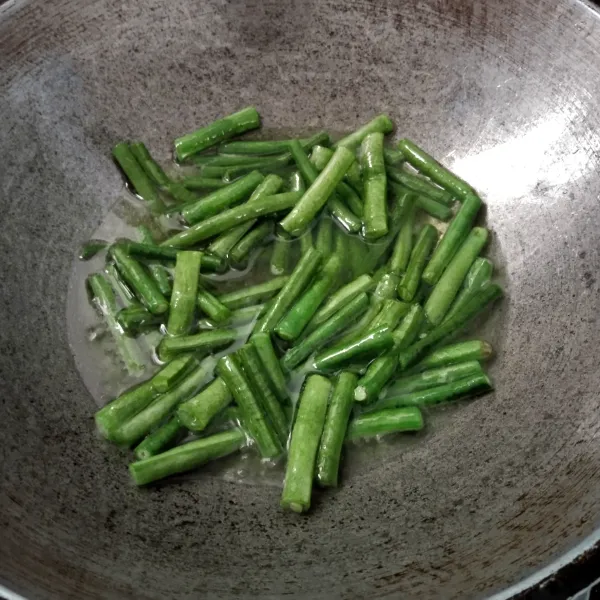 Potong kacang panjang, cuci, tiriskan lalu goreng sampai layu.