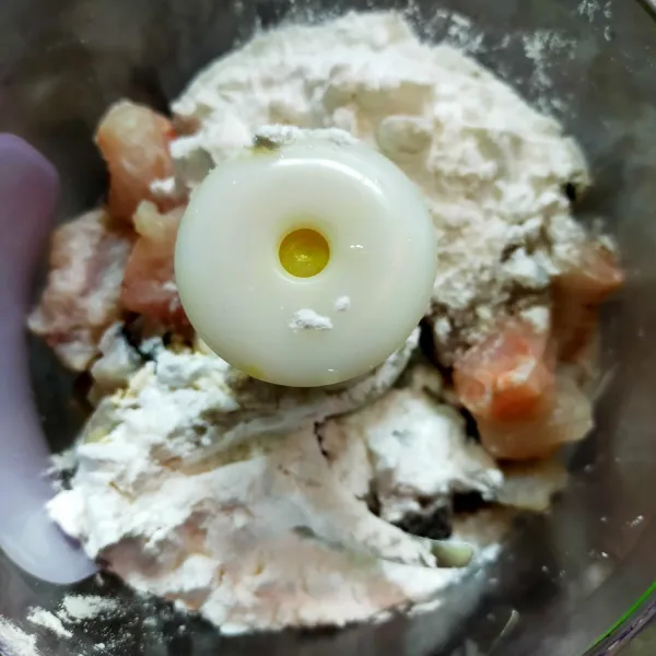 Siapkan food processor, kemudian masukkan ikan fillet, tepung tapioka, bawang putih bubuk,garam, gula pasir, kaldu bubuk, lada bubuk, putih telur.