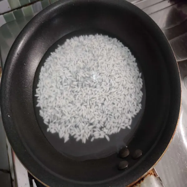 Masukkan beras ke dalam teflon anti lengket, beri air secukupnya seperti memasak nasi.