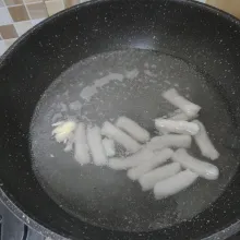Rebus tteok dan bawang putih geprek hingga mendidih dan tteok matang.