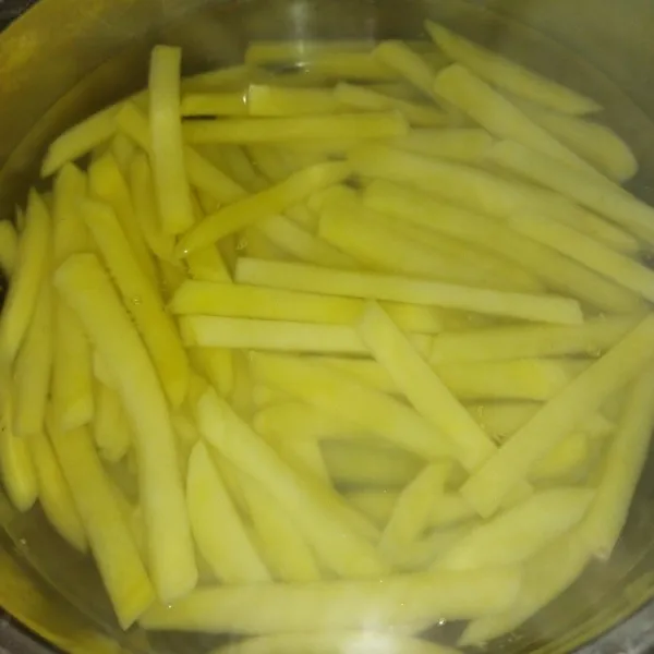 Rebus air secukupnya hingga mendidih, lalu rebus kentang sekitar 7 menit, angkat dan tiriskan, kemudian diamkan sebentar.