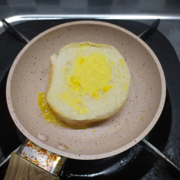 Roti burger dioles margarin, lalu dipanggang diatas teflon sebentar.