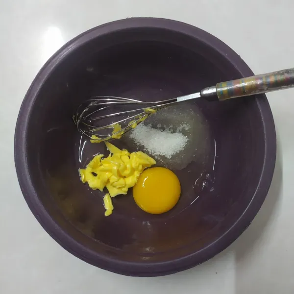 Campur margarin, gula pasir dan telur, aduk rata dengan whisker.