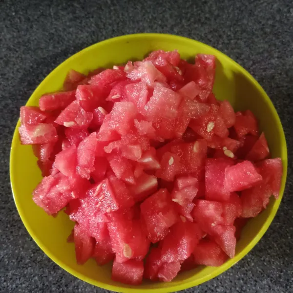Potong buah semangka dan ambil daging buahnya saja.