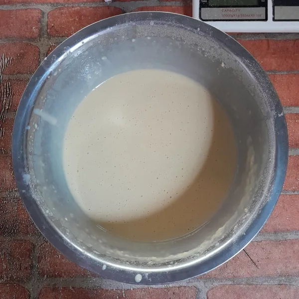 Larutkan susu kental manis dengan air, lalu tambahkan ragi dan aduk rata. Mixer semua bahan menjadi satu hingga semua bahan larut, kemudian diamkan selama 20-30 menit.