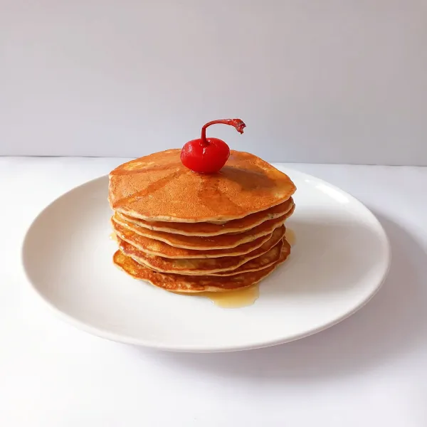 Banana Hotcakes siap disajikan bersama topping madu.