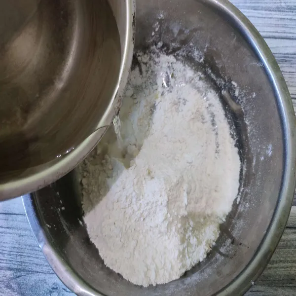 Tuang air panas ke dalam camluran tepung sedikit demi sedikit sambil diuleni hingga kalis.