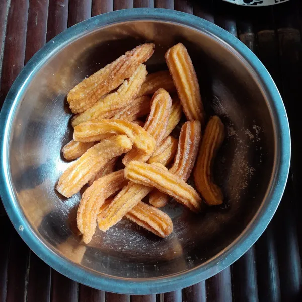 Aduk menjadi satu gula pasir dan bubuk kayu manis, baluri churros hingga rata, sajikan.