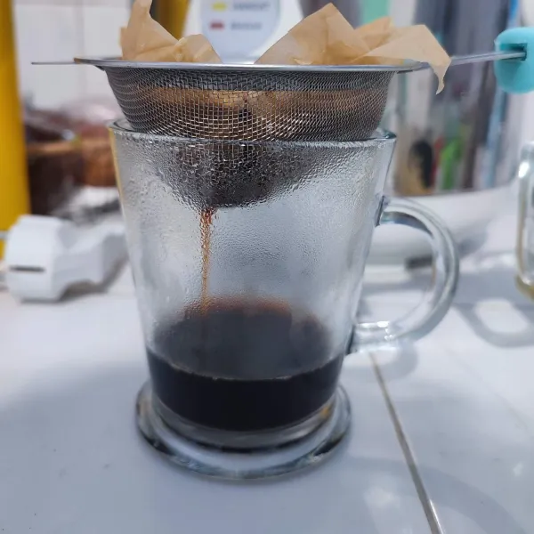 Seduh kopi dengan air panas, kemudian saring supaya ampas kopi tidak ikut tercampur.