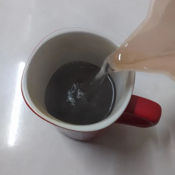 Rebus air sampai mendidih. Seduh kopi bubuk robusta dengan 150ml air panas. Aduk rata.