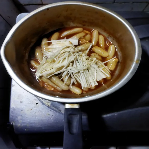 Kecilkan api, masukkan jamur enoki ke dalamnya. 
Aduk, masak hingga saus mengental. 
Koreksi rasa.