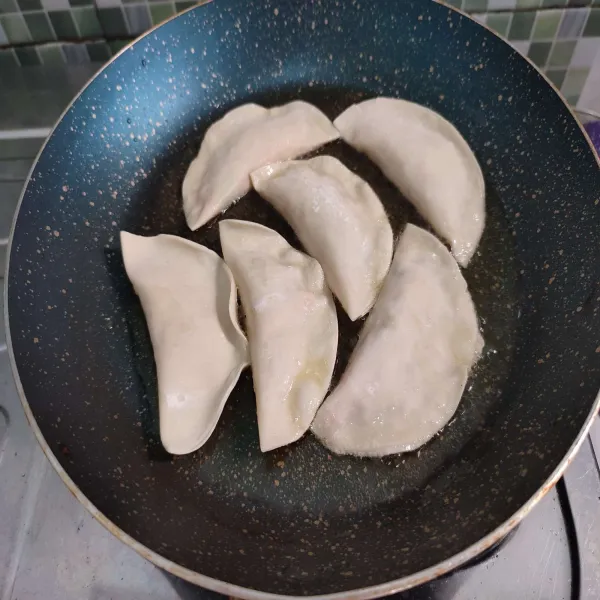 Kemudian masukkan mandu, lalu goreng hingga bagian bawahnya garing.